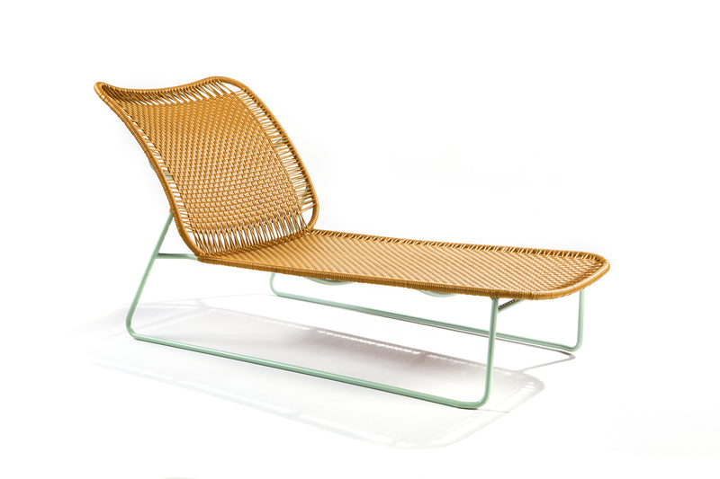 The Ames Cielo Daybed by Ames features a woven tan seat and backrest with a sleek, mint-green metal frame, inspired by Sebastian Herkner’s contemporary style and photographed on a white background.