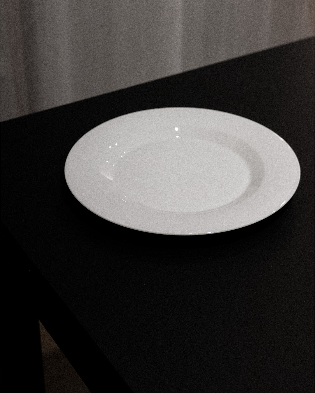An Augarten OPUS Collection plate rests on a dark table with a neutral background, where soft shadows enhance its minimalistic, clean aesthetic.