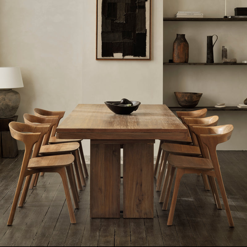 Double Extendable Dining Table in teak wood with modern solid design and six matching wooden chairs in a stylish dining room.