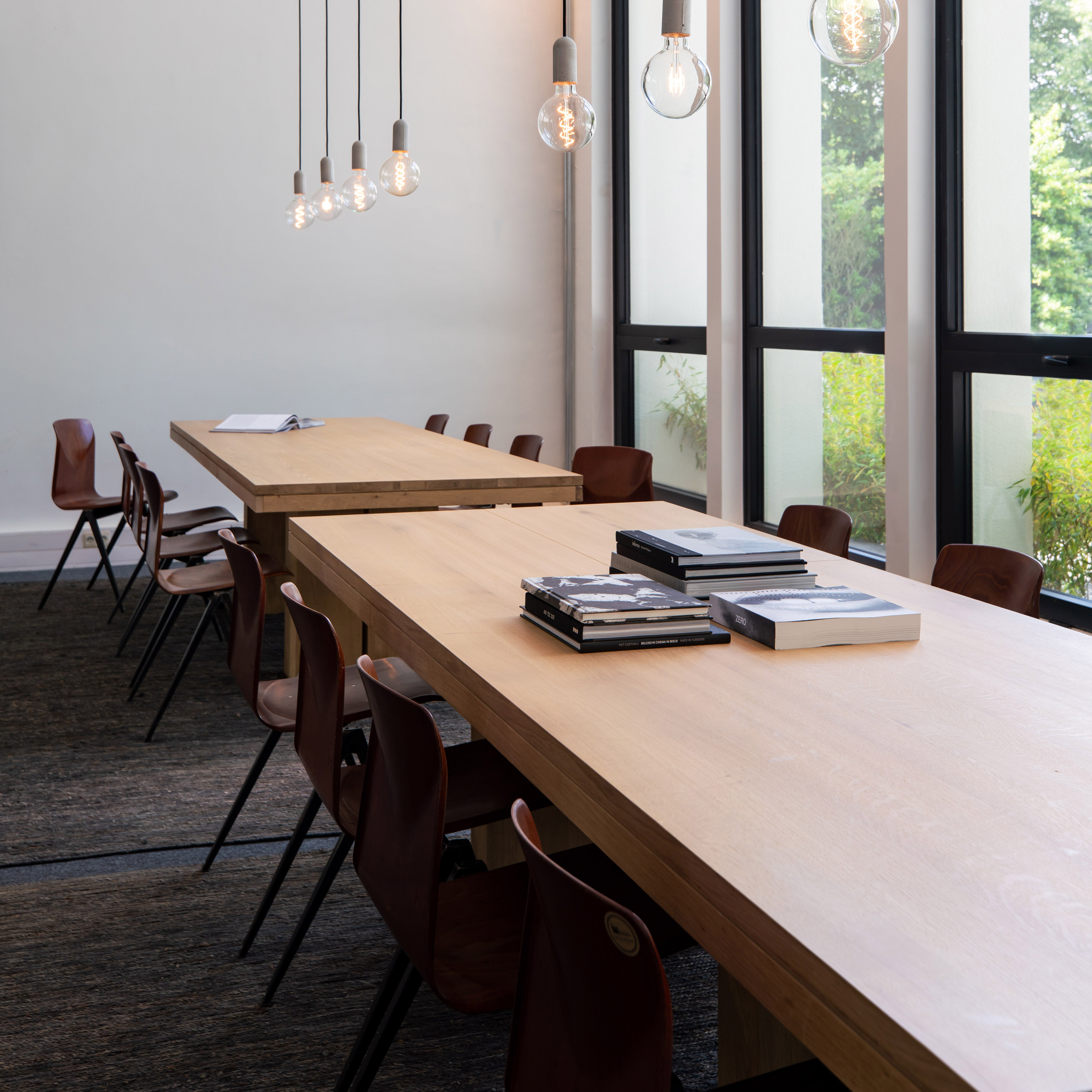 Double Extendable Dining Table with teak and oak materials in a modern room setting with chairs and pendant lighting.