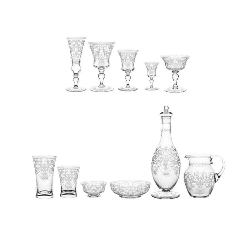 The Lobmeyr Drinking Set No. 231 - Barock features ornate glassware with hand-engraved designs, including glasses, a decanter with stopper, a pitcher, and bowls crafted from mouth-blown lead-free crystal, elegantly arranged in two rows on a plain background.