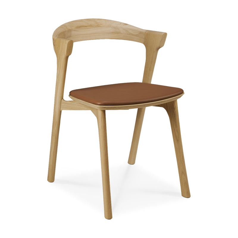 Bok Dining Chair Upholstered in varnished oak with cognac leather seat, modern ergonomic design for dining rooms.
