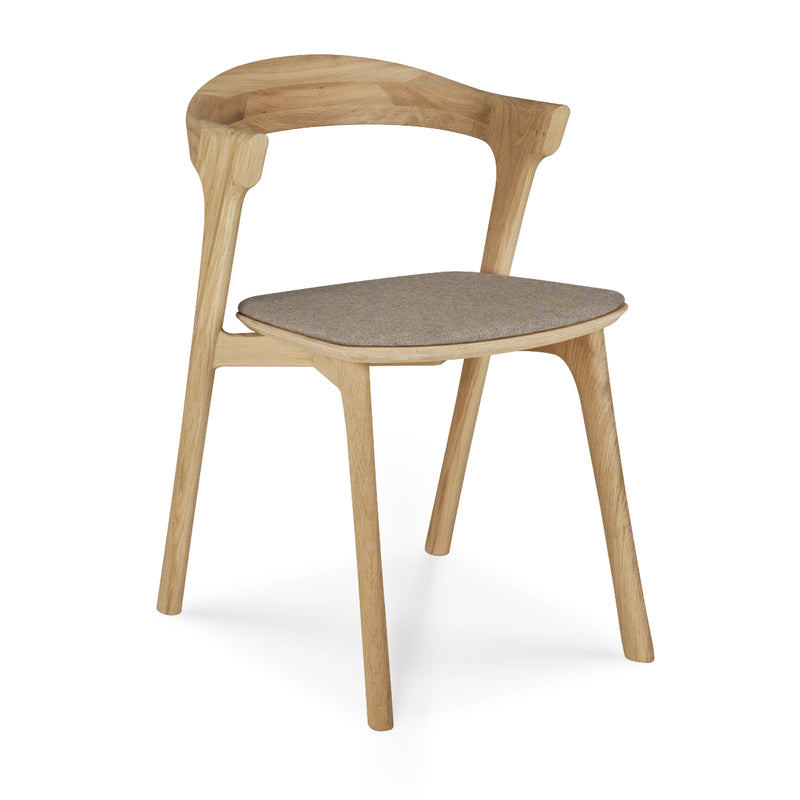 Bok Dining Chair - Upholstered in light varnished oak with a gray fabric seat cushion and ergonomic design.