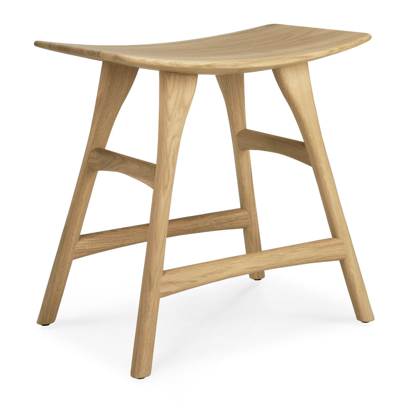The Ethnicraft Osso Stool features a curved seat and four angled legs, crafted from oak or teak with a smooth, natural wood grain for minimalist designer appeal.