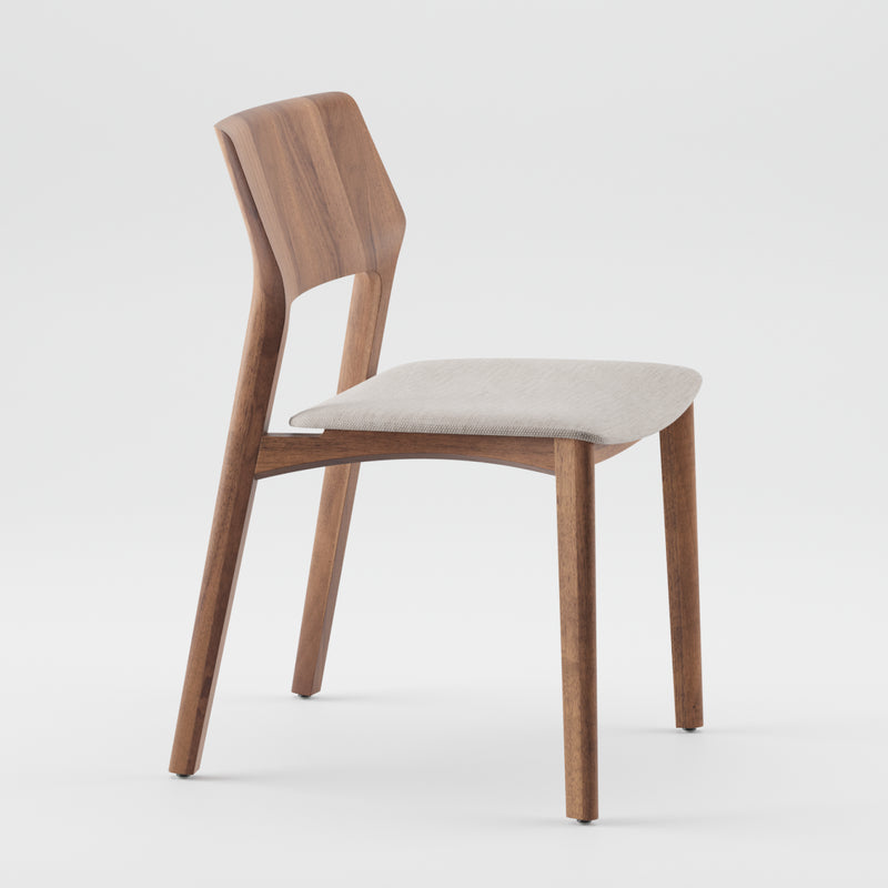 The FIN Chair Upholstered by Artisan is a modern wooden chair made from solid wood with a curved backrest and light gray cushioned seat. This minimalist design has angled legs, using eco-friendly materials and natural oils, shown against a plain white background.