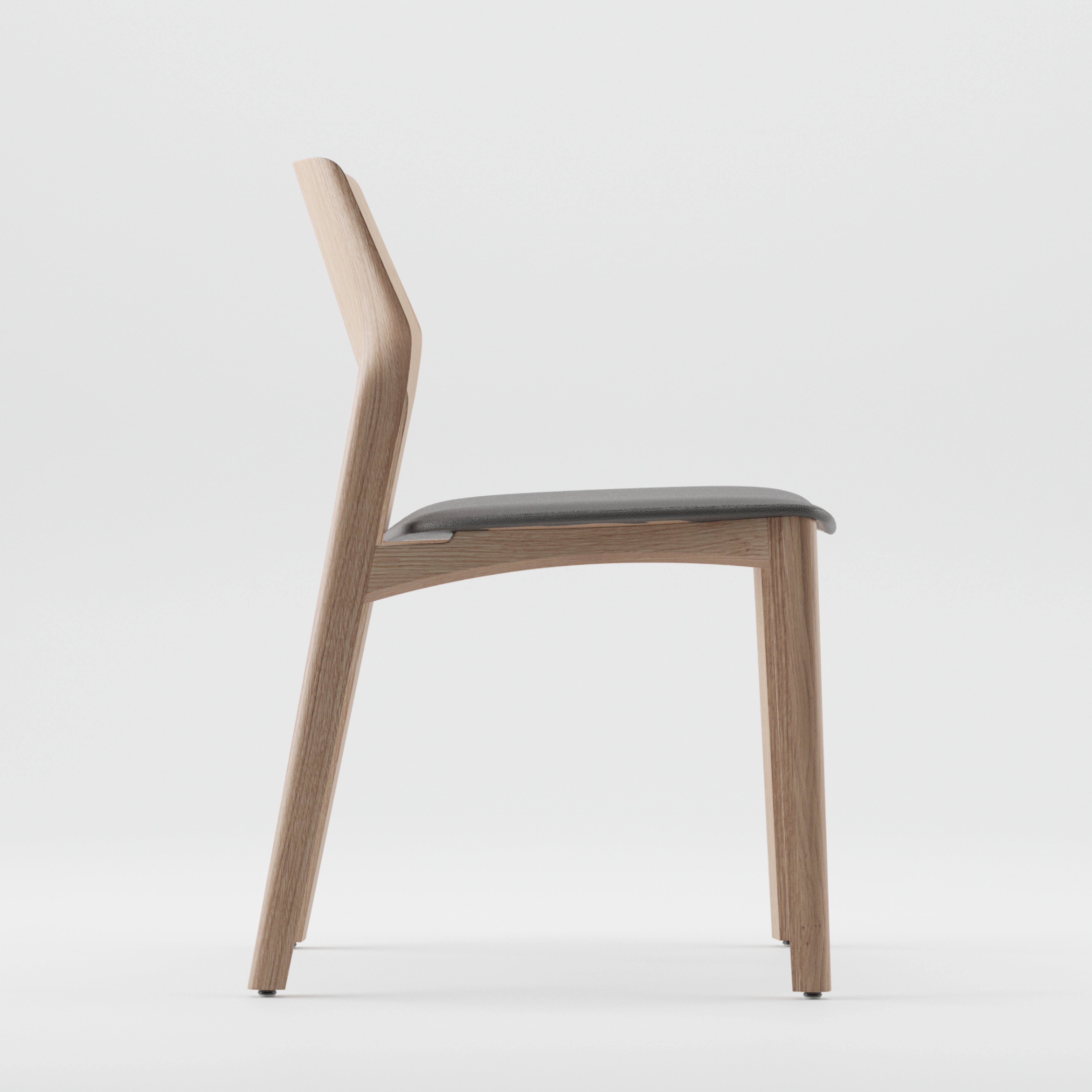The FIN Chair Upholstered by Artisan features a minimalist design with a solid wood frame finished in natural oils and a dark cushioned seat. It boasts an eco-friendly design, straight backrest, and simple elegance, all set against a plain white background.
