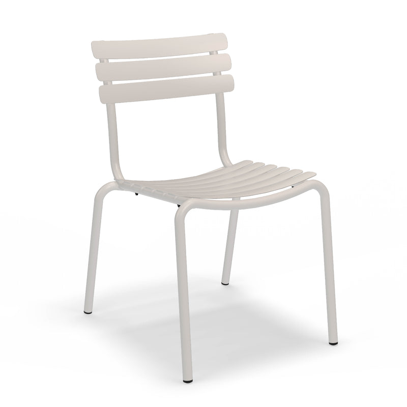 The Houe Alua Dining Chair, made of minimalist aluminum with a slatted seat and backrest, is designed for indoor or outdoor use. This sleek, four-legged chair offers a modern look and a stackable design for versatile seating in any setting.