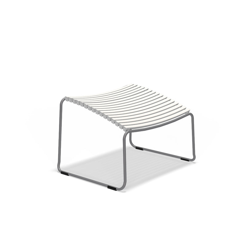 The Click Footrest by Houe is a modern minimalist bench with sleek white plastic lamellas, a gray metal frame, and curved legs, featuring a UV-protected lightweight design.