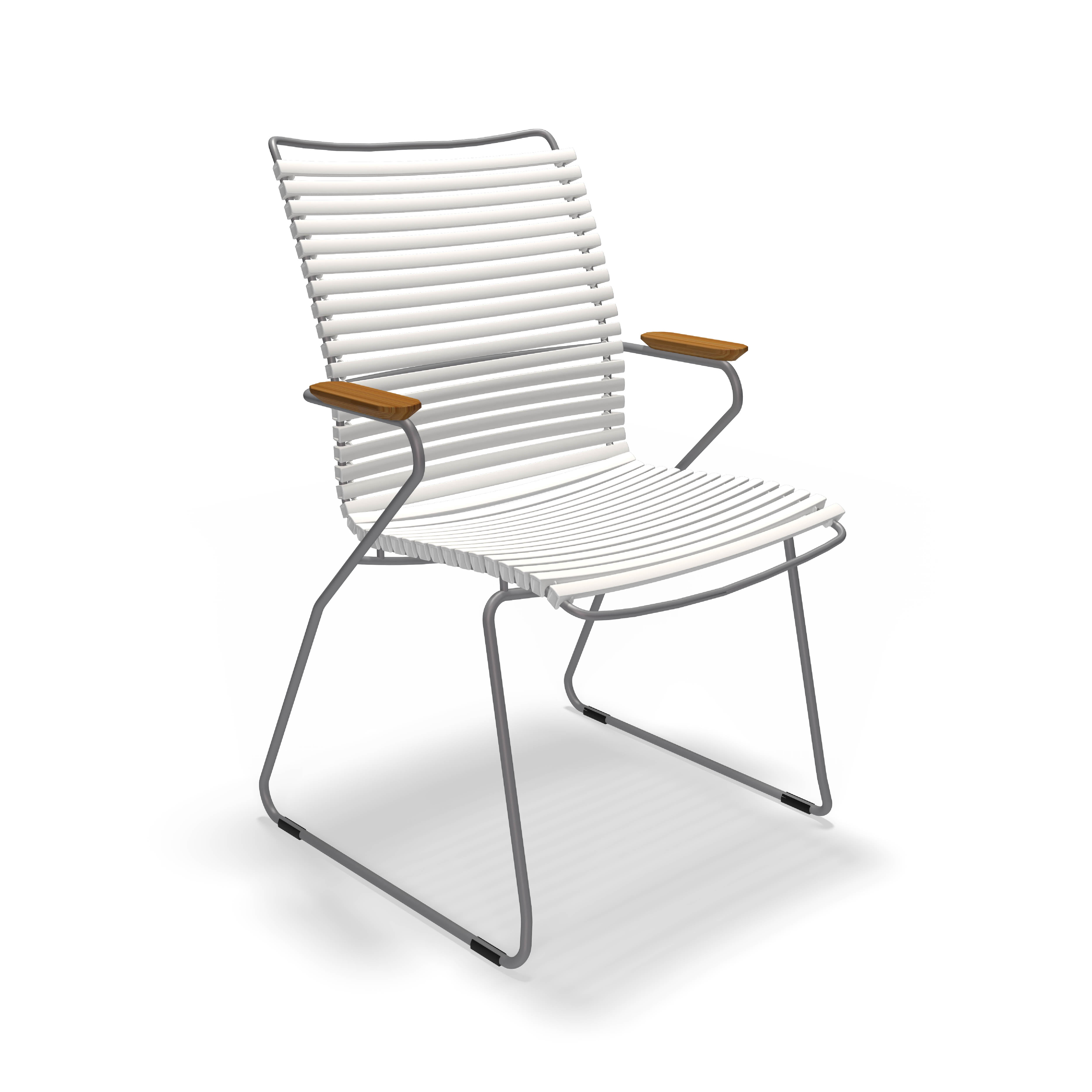 The Click Dining Chair with Armrest - Tall Back from Houe combines a modern outdoor look with UV-protected white ribbed metal seat and backrest, angled chrome legs, light brown wooden armrests, and a weather-resistant minimalist design.