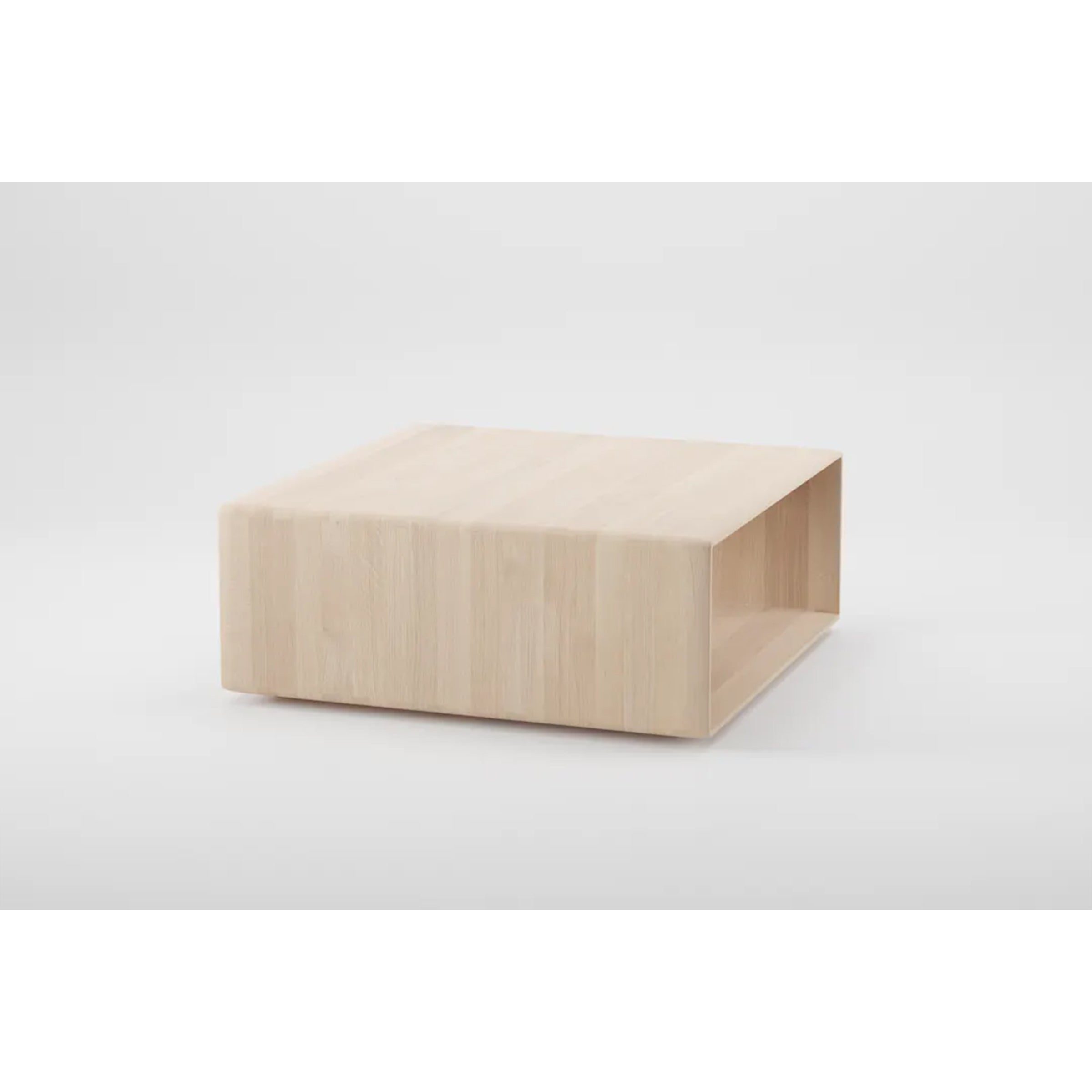The INVITO Cube Coffee Table by Artisan is a square, solid wood piece with a light, natural finish. It features a minimalist design with clean lines and an open shelf beneath the tabletop. Made from environmentally-friendly materials, it stands out against a plain white background.