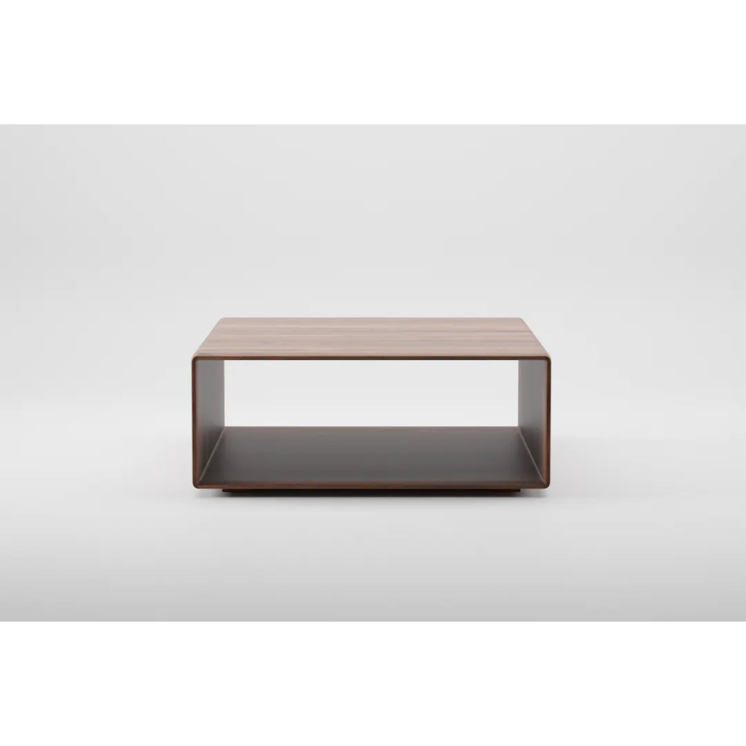 The INVITO Cube Coffee Table by Artisan is a sleek, minimalist piece made of solid wood with a natural oil finish. It has an open shelf and stands on a flat base. Its eco-friendly design is highlighted against a plain white background.
