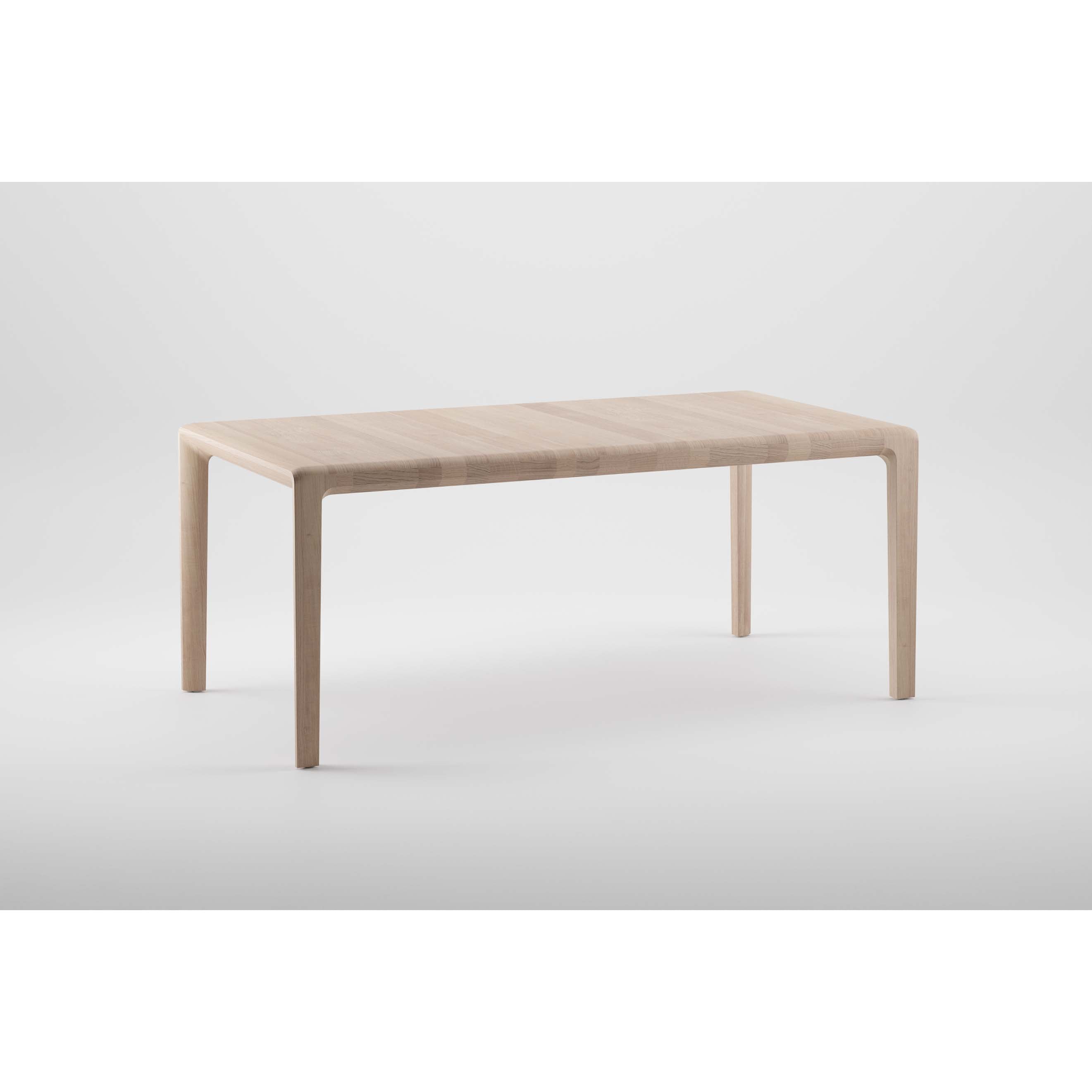 The INVITO Table by Artisan is a minimalist piece made from solid, light-colored wood with a natural oil finish. It features a smooth surface and four slender legs, set against a plain white background.
