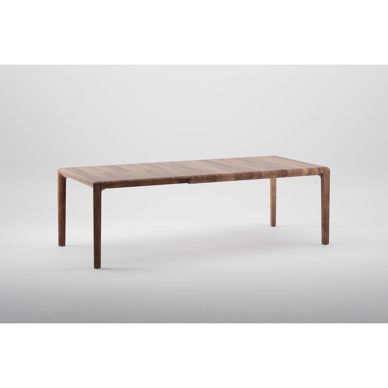 The INVITO Table Extendable by Artisan is a sleek, modern rectangular table crafted from solid wood, featuring rounded edges and four legs. Set against a white background, its polished finish and eco-friendly materials highlight its simple design.