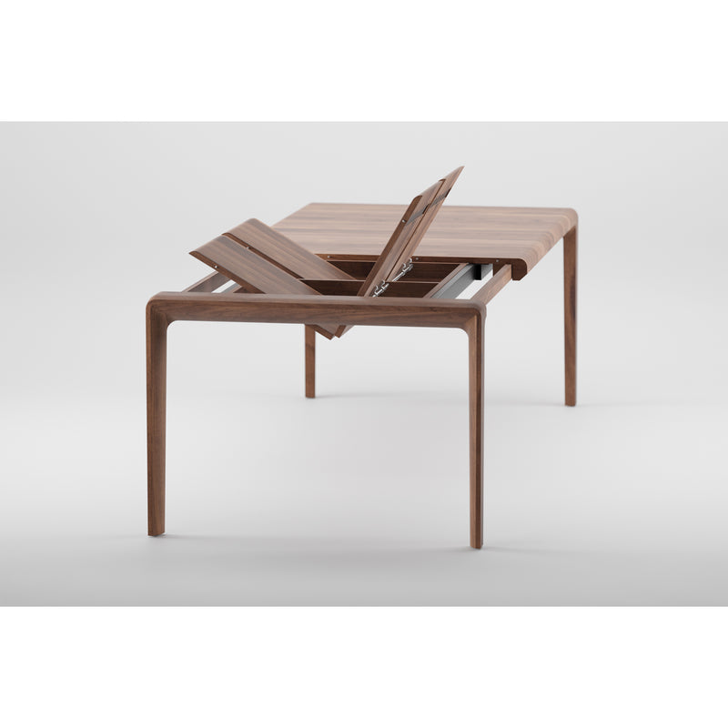 The INVITO Table Extendable by Artisan is a solid wood dining table with modern, sleek lines, featuring a central lift section to extend its length. Crafted from eco-friendly materials, this efficient design stands out on a white background.