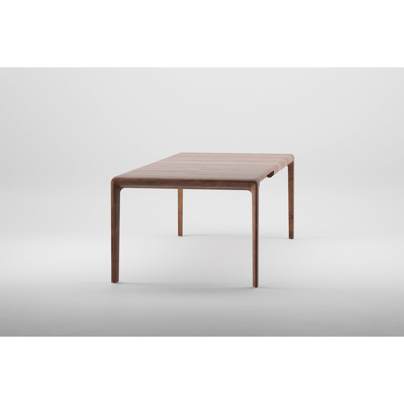 The INVITO Table Extendable by Artisan is a minimalist, rectangular wooden table with slightly rounded edges. Crafted from solid wood and finished with natural oils, its smooth texture and elegant simplicity stand out against a plain white background.