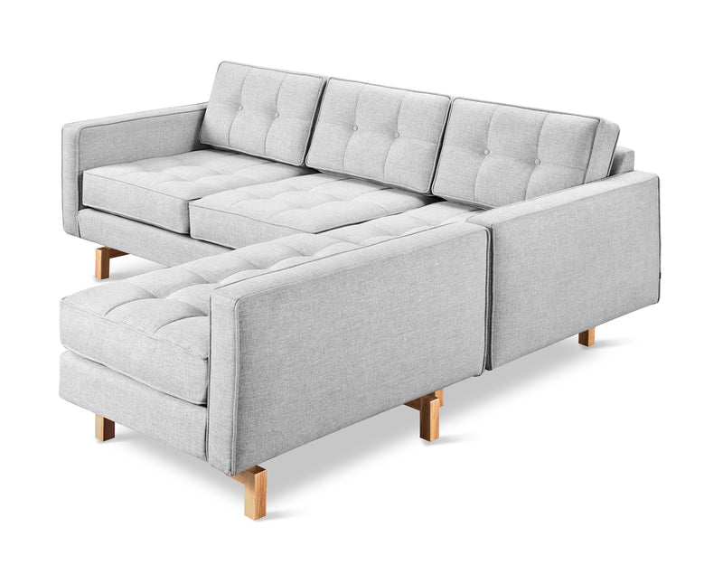 The Gus Modern Jane 2 LOFT Bi-Sectional features a light gray, mid-century-inspired design with tufted cushions, wooden legs, a left chaise lounge, and clean lines that highlight its minimalist style.