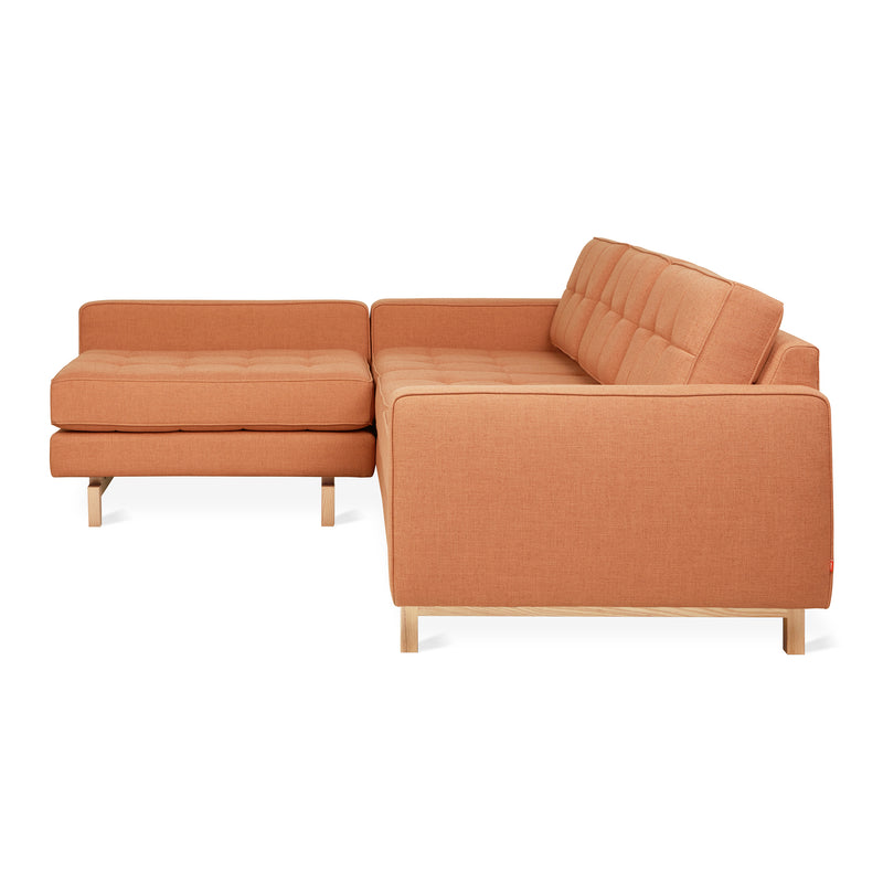 The Jane 2 LOFT Bi-Sectional Natural Finish Base by Gus Modern features tufted cushions, a left-facing chaise, and light wooden legs—a striking mid-century sofa that adds modern style to any living space.