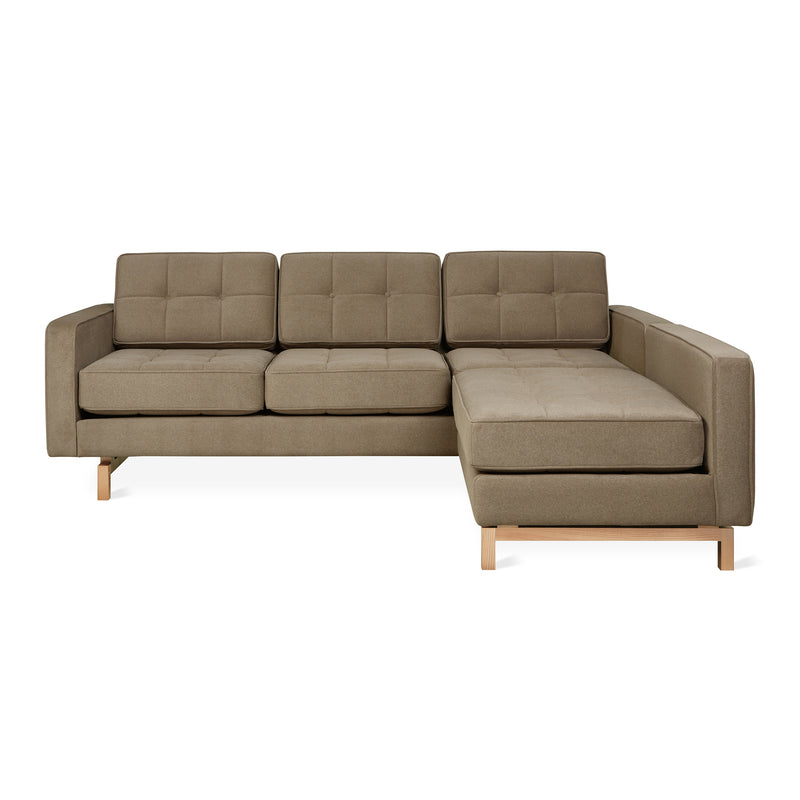 The Jane 2 LOFT Bi-Sectional by Gus Modern features brown upholstery, tufted cushions, and a natural finish base, showcased against a white background.