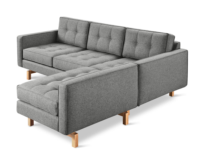 The Gus Modern Jane 2 LOFT Bi-Sectional features a natural finish base, gray fabric upholstery, tufted cushions, wooden legs, and a left-side chaise lounge for modern mid-century style.