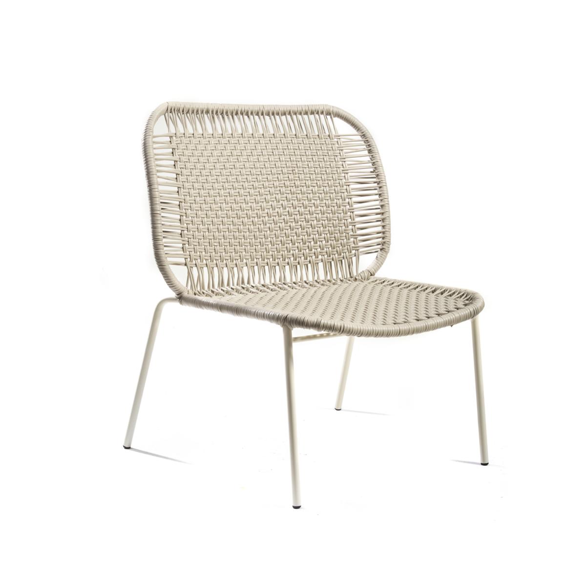The Ames Cielo Lounge Chair Low by Ames features a modern armless design with a woven rattan seat and back, supported by slender white metal legs. Suitable for indoor or outdoor use, it is shown against a plain white background.