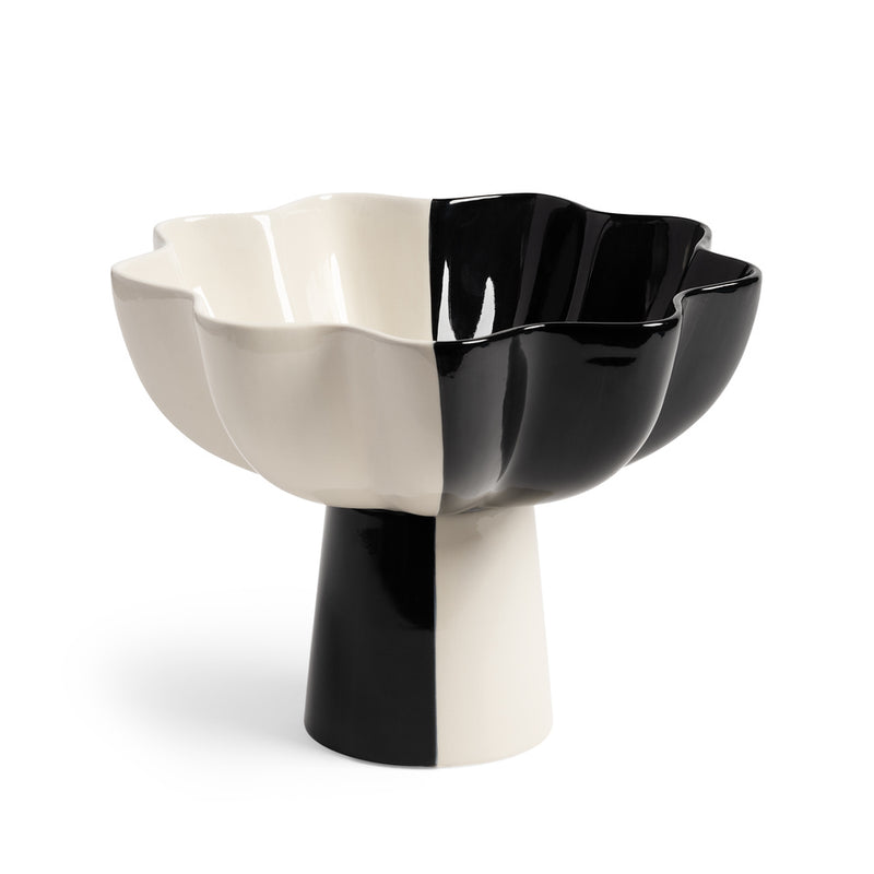 The Fruit Bowl Sun Black Large by &Klevering features a wavy edge and a pedestal base, divided into black and white. Its glossy surface enhances its symmetrical design, with subtle multicolor hints adding whimsy.