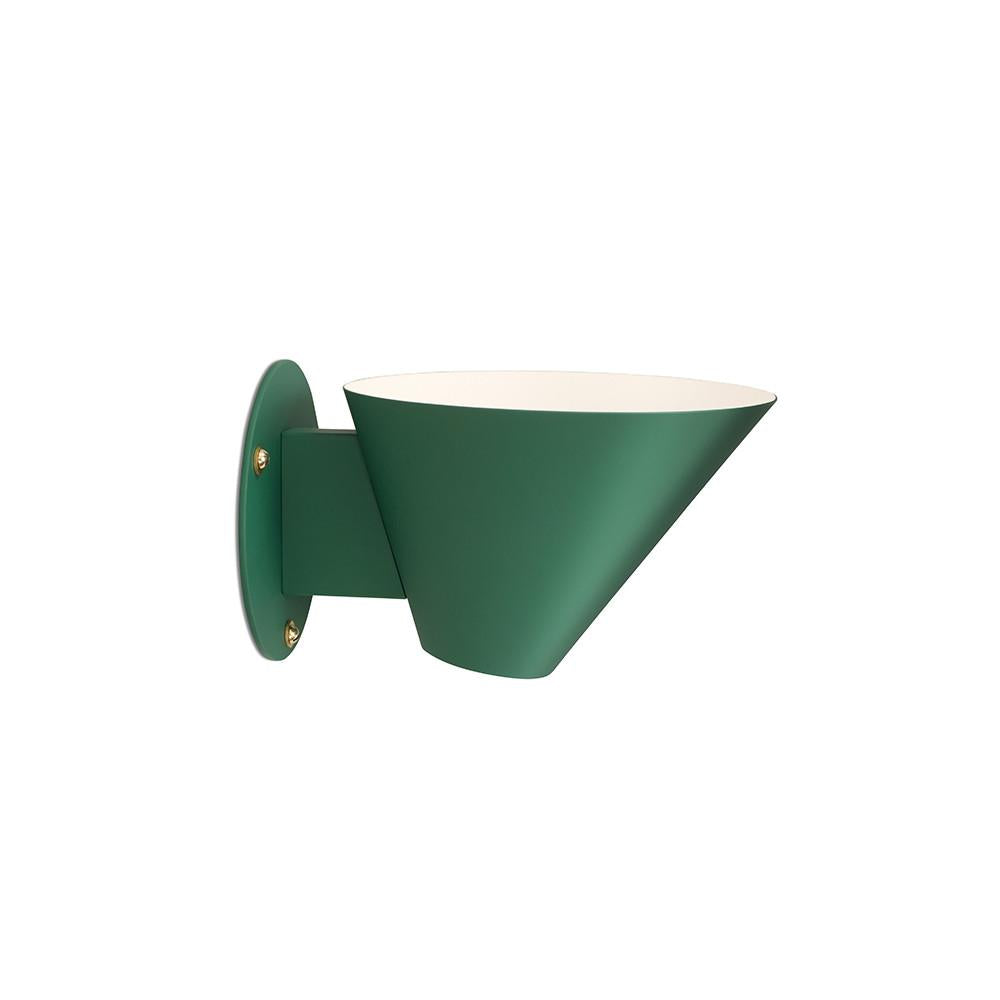 The Billy Wall by Kalmar is a green, wall-mounted light fixture crafted from lacquered metal with a conical shade and circular base. Its white interior directs light outward, blending industrial design with minimalist and modern aesthetics.