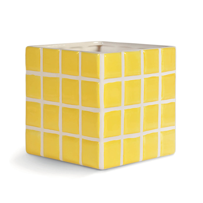 The Vase Tile Yellow by &Klevering is a cube-shaped tissue box cover. It features a candy-colored design with bright yellow sides and square tiles outlined in white, plus an opening on top for tissues.