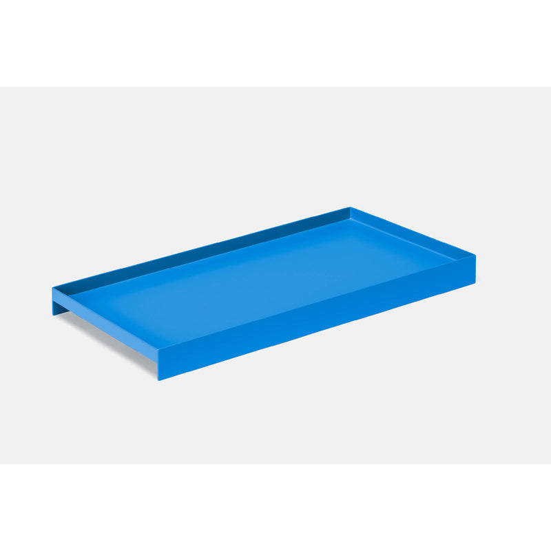 The Loehr L3 COURT is a minimalist blue rectangular serving tray with raised edges, set against a plain light gray background. Its sleek design and smooth material make this steel tray a versatile accessory for any modern setting.