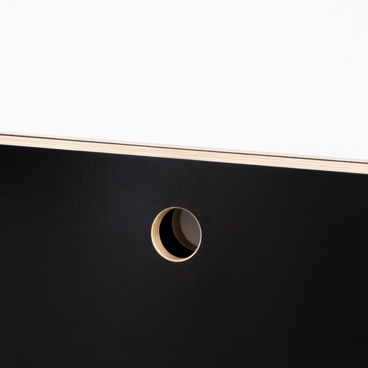 A close-up of Moormanns Last Minute panel against a white background features a sleek, space-saving design with a circular cut-out revealing its layered structure, akin to stylish foldable furniture, enhanced by the interplay of light and shadow.