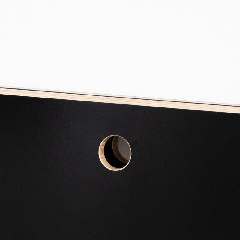 A close-up of Moormanns Last Minute panel against a white background features a sleek, space-saving design with a circular cut-out revealing its layered structure, akin to stylish foldable furniture, enhanced by the interplay of light and shadow.