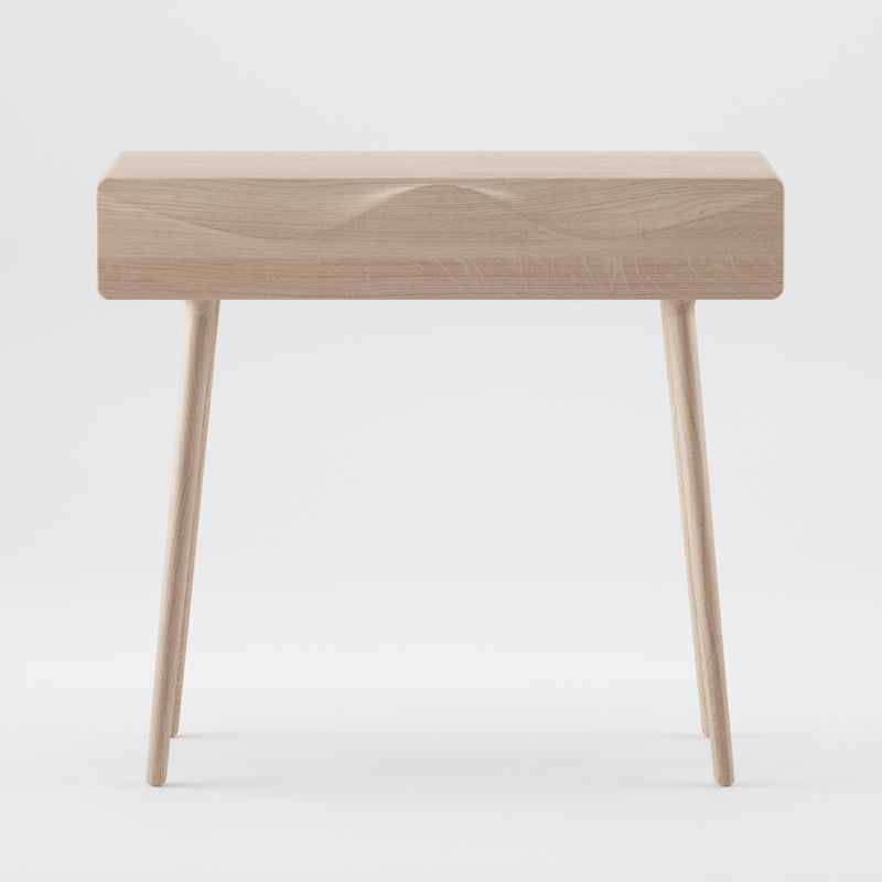 The LASTA Console Table by Artisan is a minimalist solid wood table with clean lines, a rectangular top, and three slightly angled legs. It features an eco-friendly natural wood finish and is displayed against a plain white background.