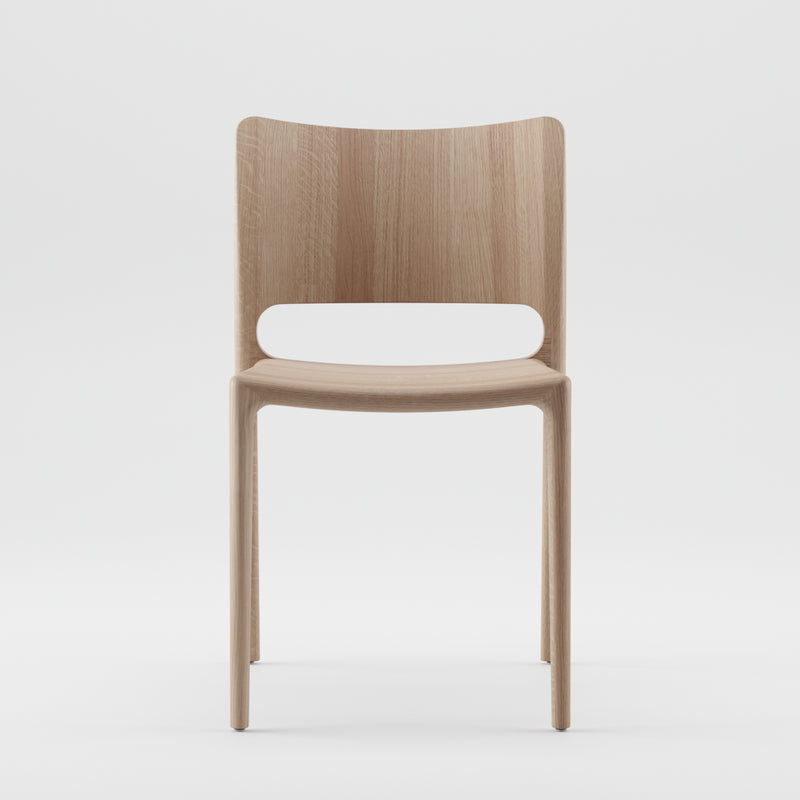 The LATUS Chair by Artisan is a simple, modern wooden chair crafted from solid wood with a smooth, light finish. It features a curved backrest and minimalist design and is made using environmentally-friendly materials, set against a plain white background.