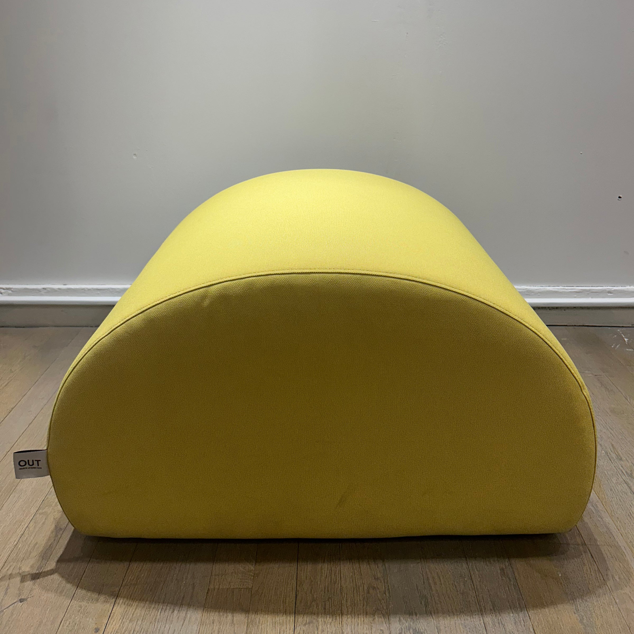 Levi Pouf - Sale in vibrant yellow upholstery with a smooth, rounded organic shape on wooden floor background
