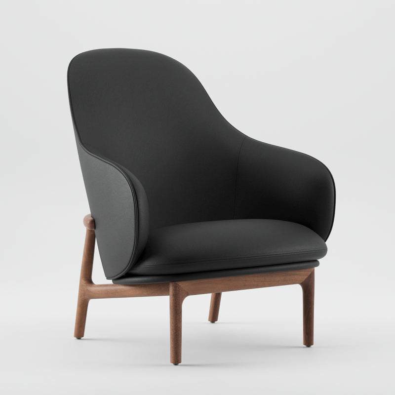 The MELA Lounge Chair High by Artisan features a sleek black seat and backrest with smooth curves, inspired by mid-century style. Its wooden legs and open back design provide a minimalist and elegant look against a plain white background.