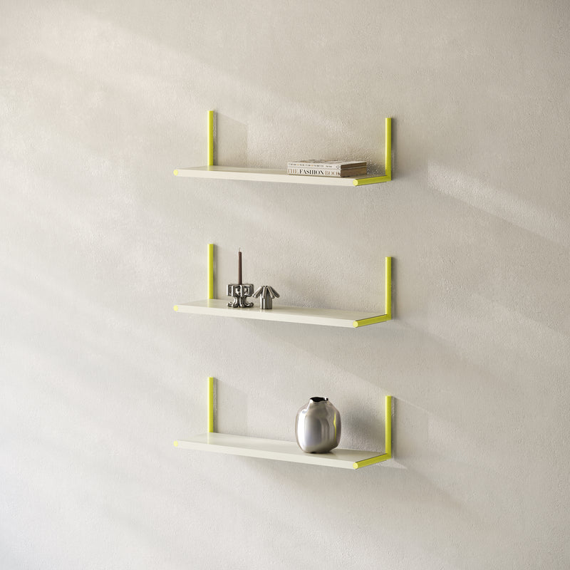 Three ELLE Shelf units mounted vertically with yellow brackets holding decor and books on a light wall.