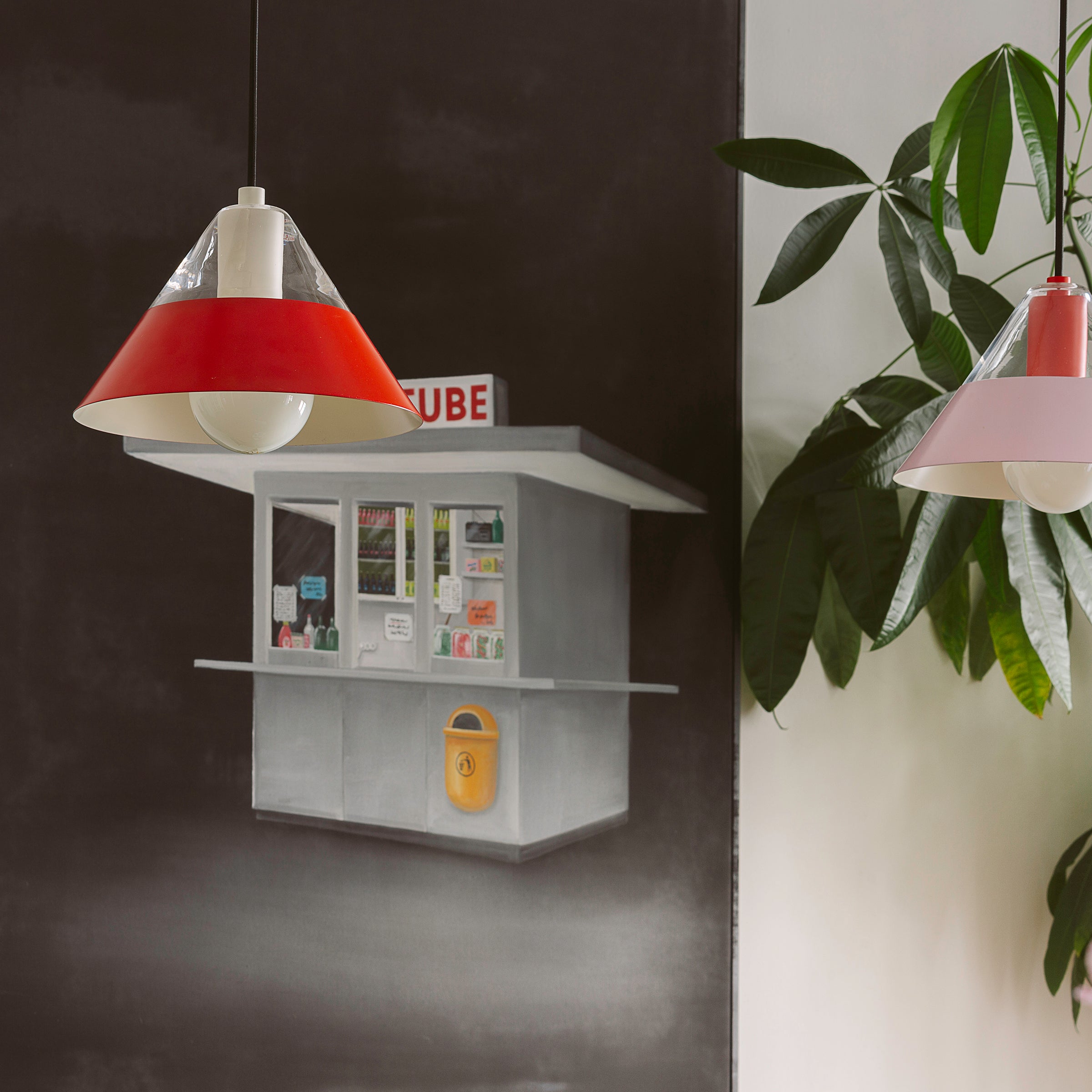 FIFTY FIFTY lamp with a red metal shade and glass top, showcasing a modern design with soft upward and focused downward light.