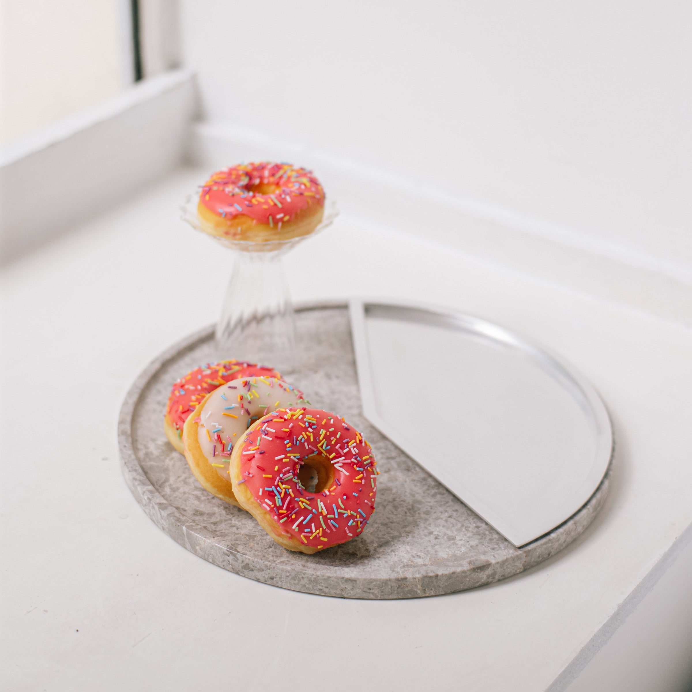 5 O' CLOCK Tray with round marble base and aluminum inlay, displaying donuts and glass on white surface.