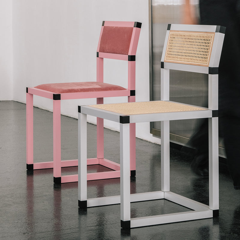 Two XD Chairs with aluminum frames, one in pink velvet upholstery and one in white frame with woven seat and backrest.