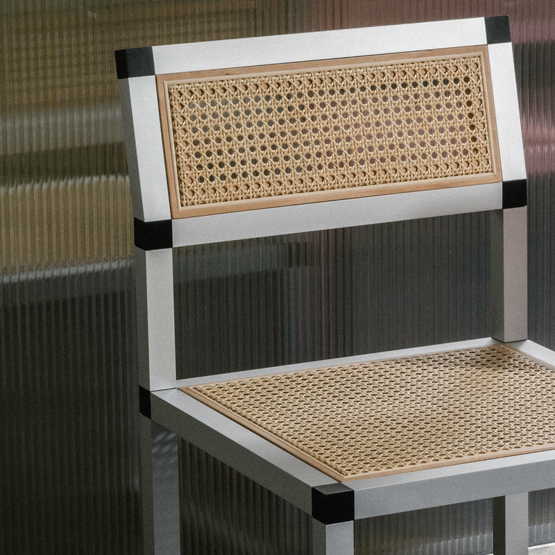 XD Chair Cane with aluminum frame and cane upholstery featuring matte finishes and black connectors.