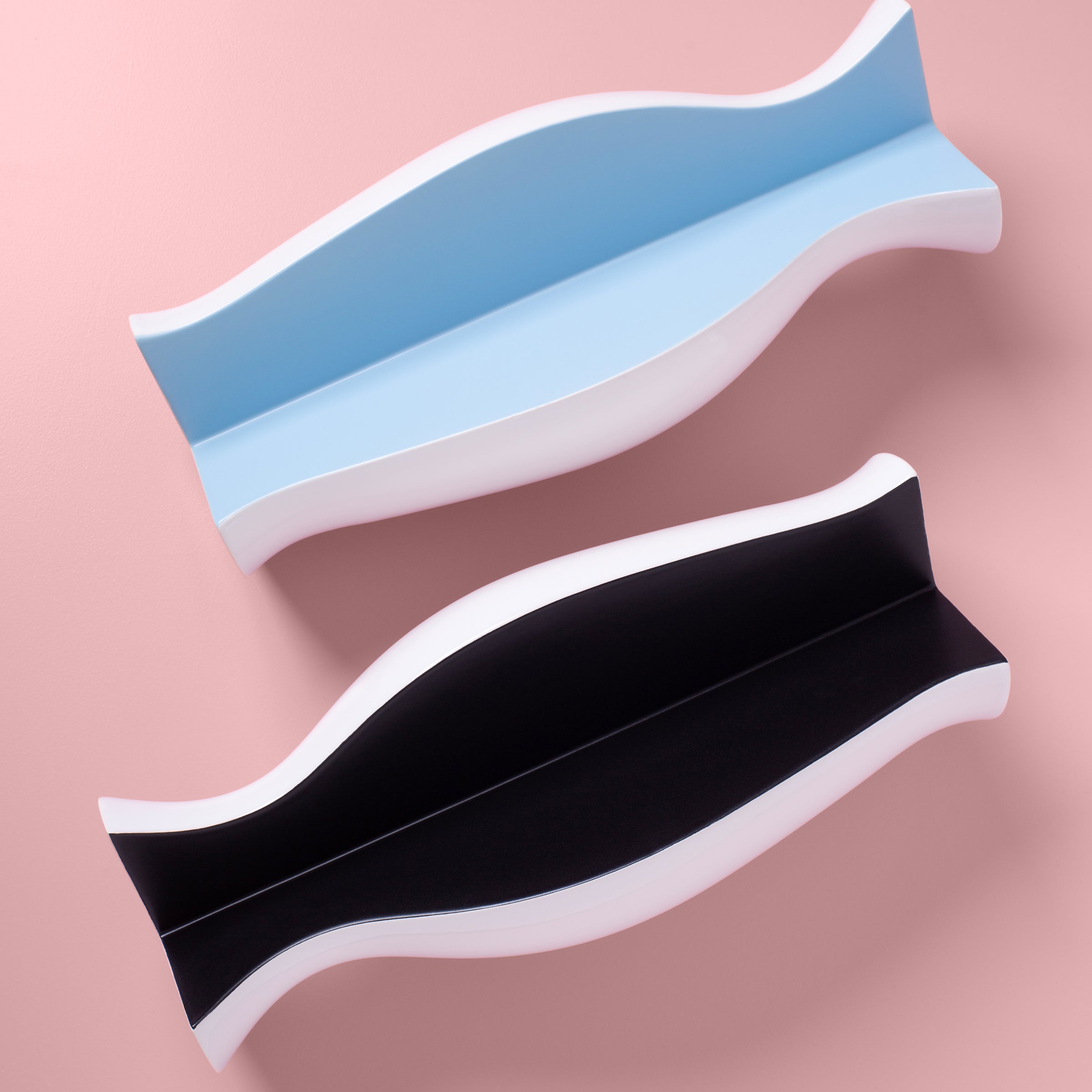QUATER Vase III showing two curved ceramic pieces in black and light blue with white edges on a pink background