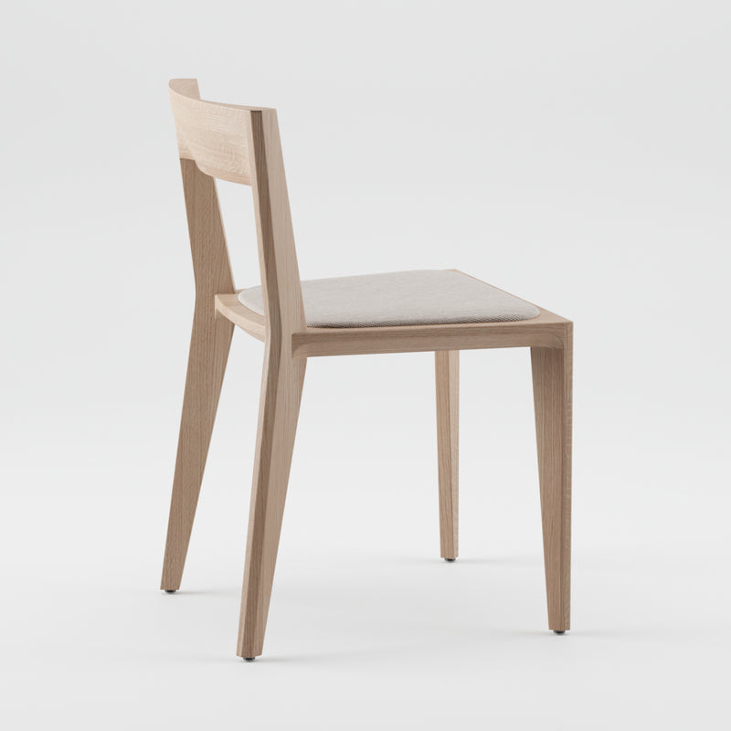 The HANNY Chair by Artisan is a modern piece with a sleek design, crafted from solid wood. It features a light beige seat cushion, straight lines, slender legs, and an upright backrest. Each chair is made using environmentally-friendly materials and photographed against a plain white backdrop.