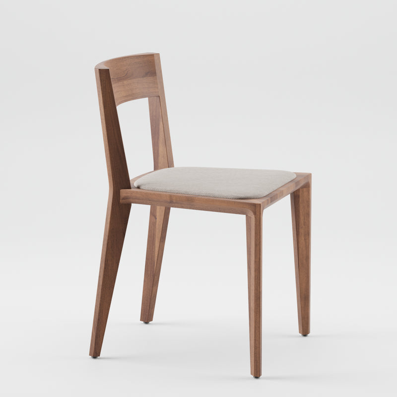The HANNY Chair by Artisan boasts a minimalist design crafted from solid wood with a medium brown finish. It features straight, narrow legs, a slightly curved backrest, and a light gray cushioned seat, all set against a plain white background.