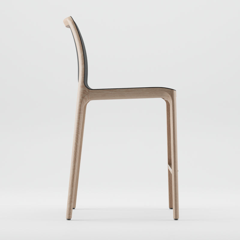 Side view of the minimalist INVITO Barstool by Artisan, featuring a modern design with solid wood construction, a curved backrest, and slender legs on a white background.