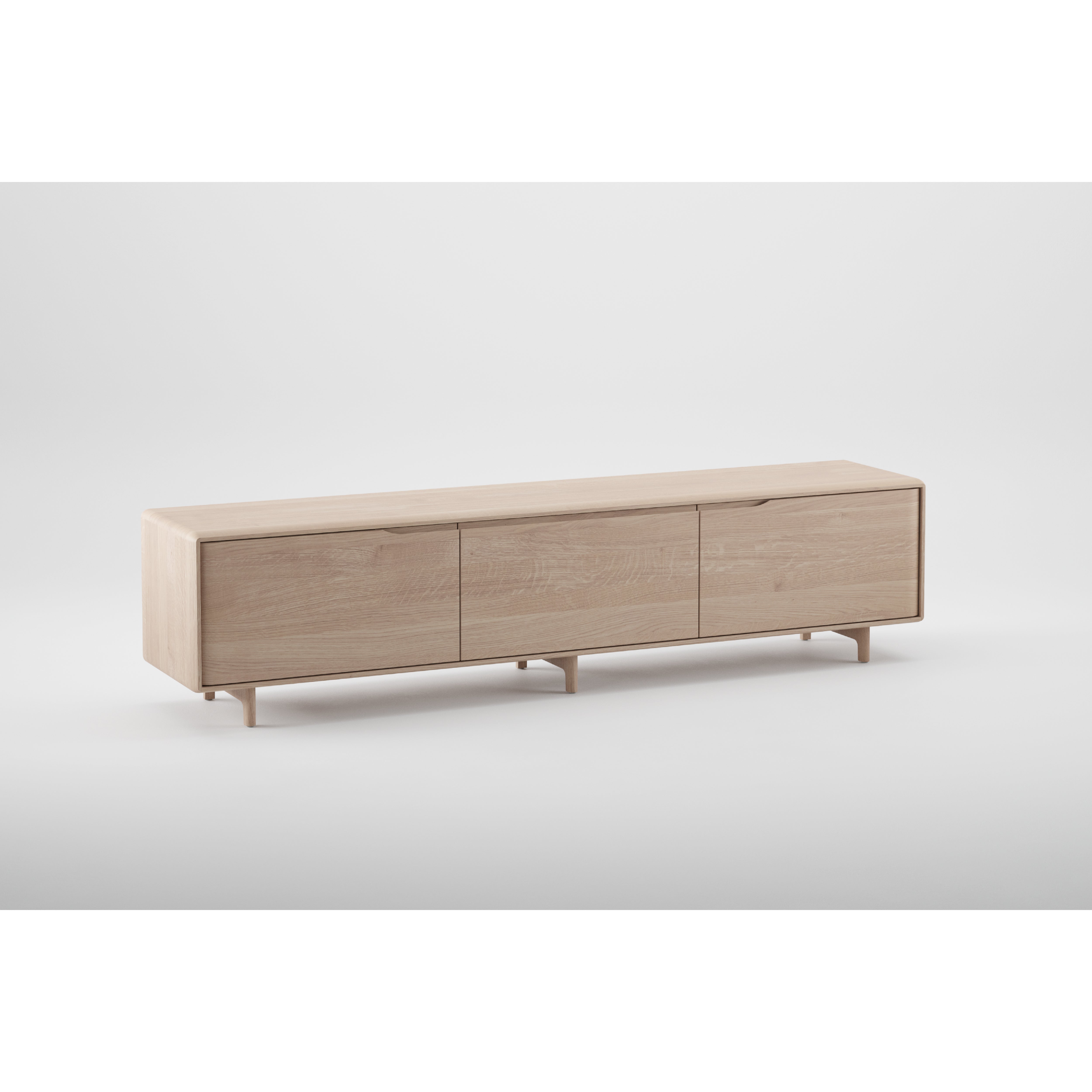 The INVITO Lowboard by Artisan features a sleek, minimalist design in solid wood with a light natural finish and three sliding doors. Elevated on small legs, its crafted with environmentally-friendly materials to enhance any space against a plain white background.
