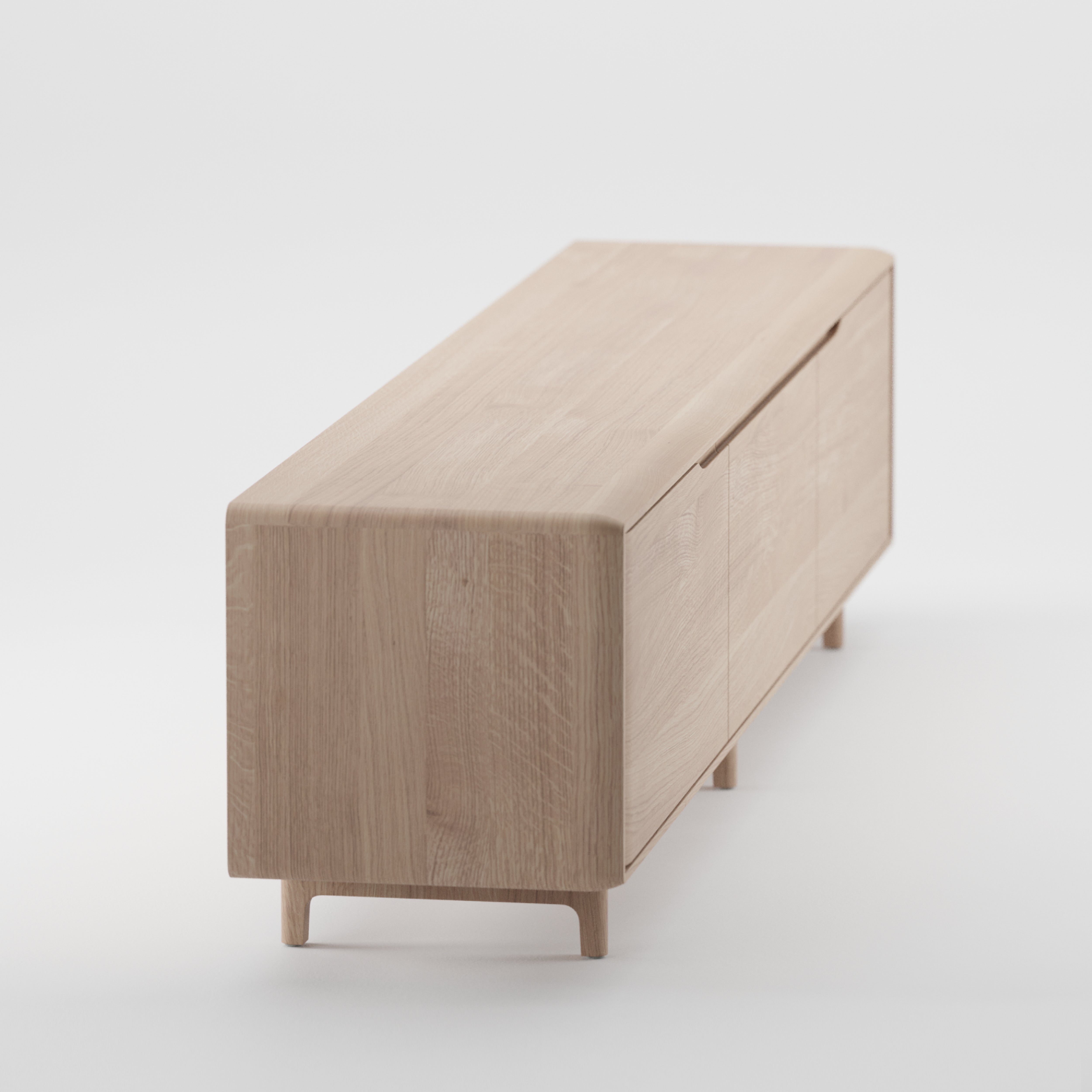 The Artisan INVITO Lowboard is a minimalist wooden sideboard made from solid, eco-friendly materials with a light wood finish. It has four cabinet doors and short legs on a plain white background, emphasizing its natural wood texture and enhancing luster with natural oils.