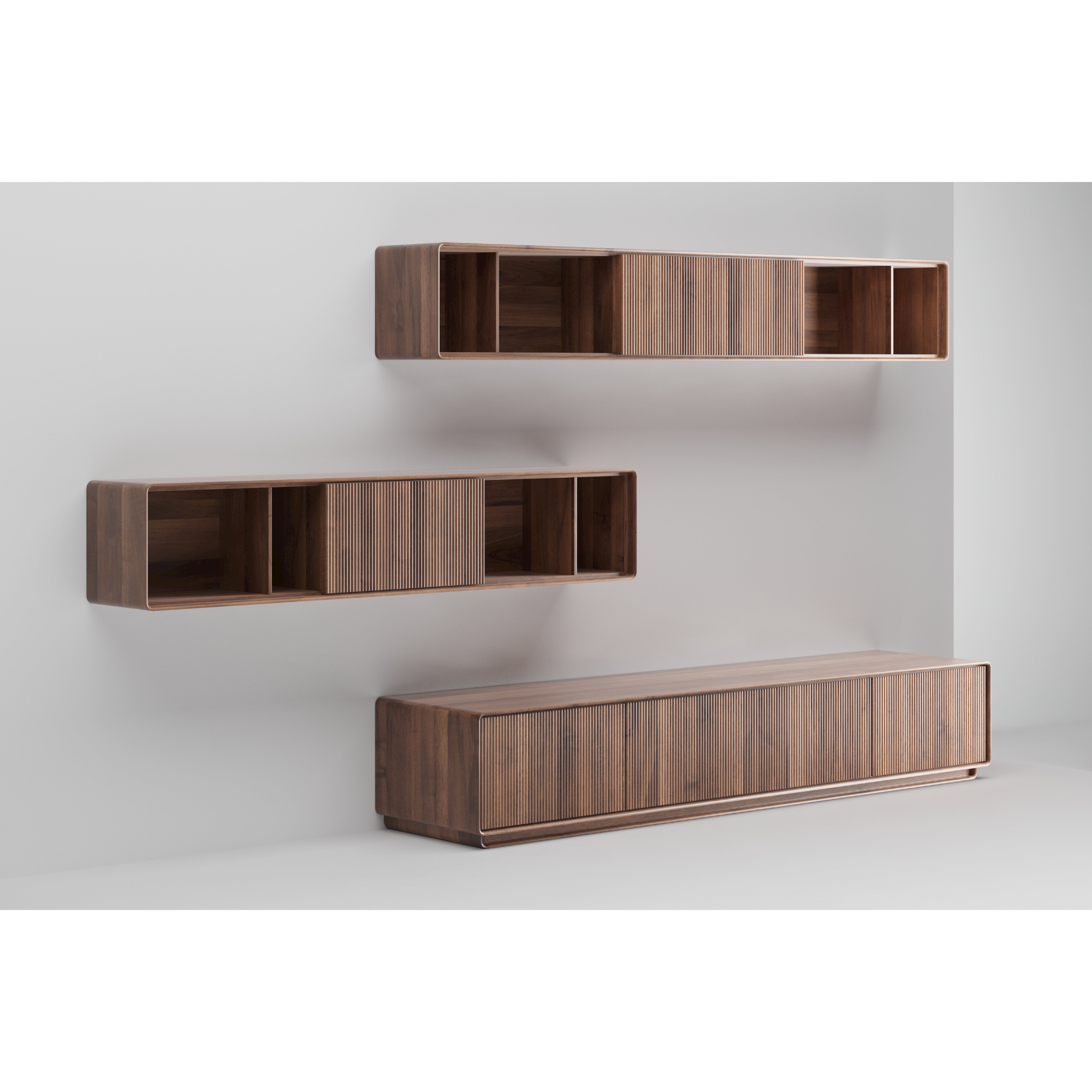 Three modern Artisan JANTAR Modular System wall-mounted cabinets in solid wood are displayed against a white wall. Two smaller upper cabinets feature open compartments, while the larger lower cabinet with a smooth front provides an eco-friendly, minimalist storage solution.