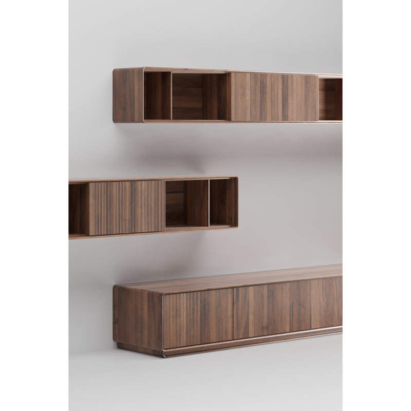 Artisans JANTAR Modular System comprises minimalist wall-mounted wooden shelves and a long cabinet. Crafted from solid wood with a natural oil finish, it features clean lines, open storage compartments, and offers a warm, inviting feel against a plain white background.
