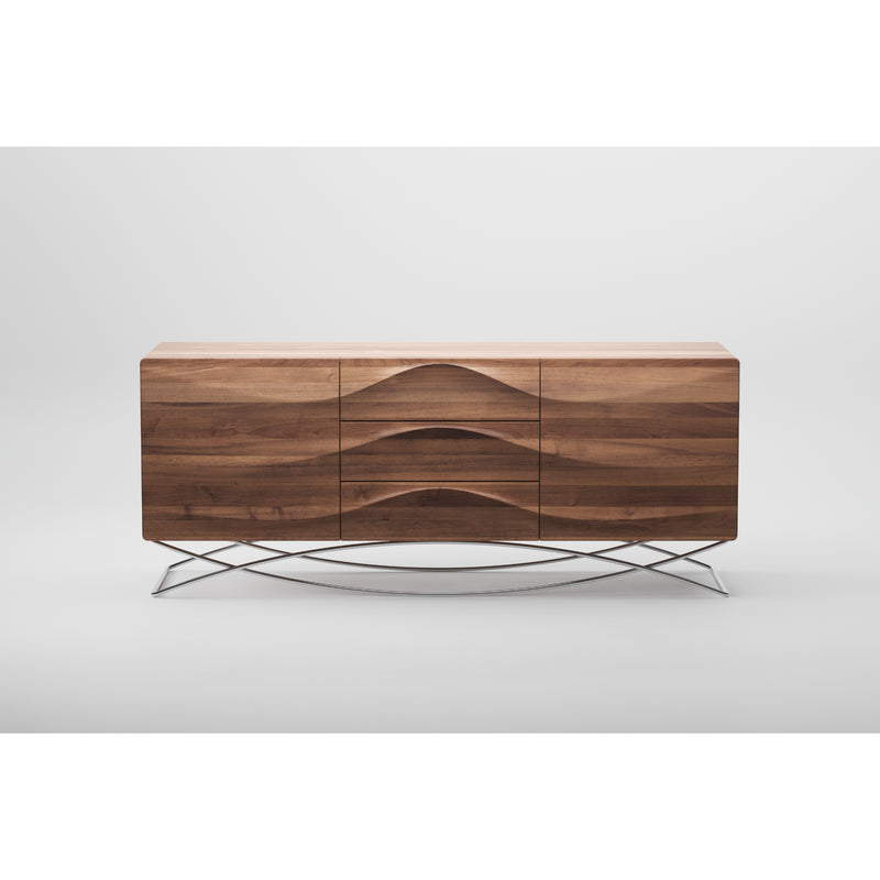 The LASTA Sideboard by Artisan, crafted from solid wood, showcases a smooth wave-like pattern on two doors and three drawers. It stands on thin metal legs with a cross-brace design, finished in natural oils for eco-friendliness, set against a plain white background.