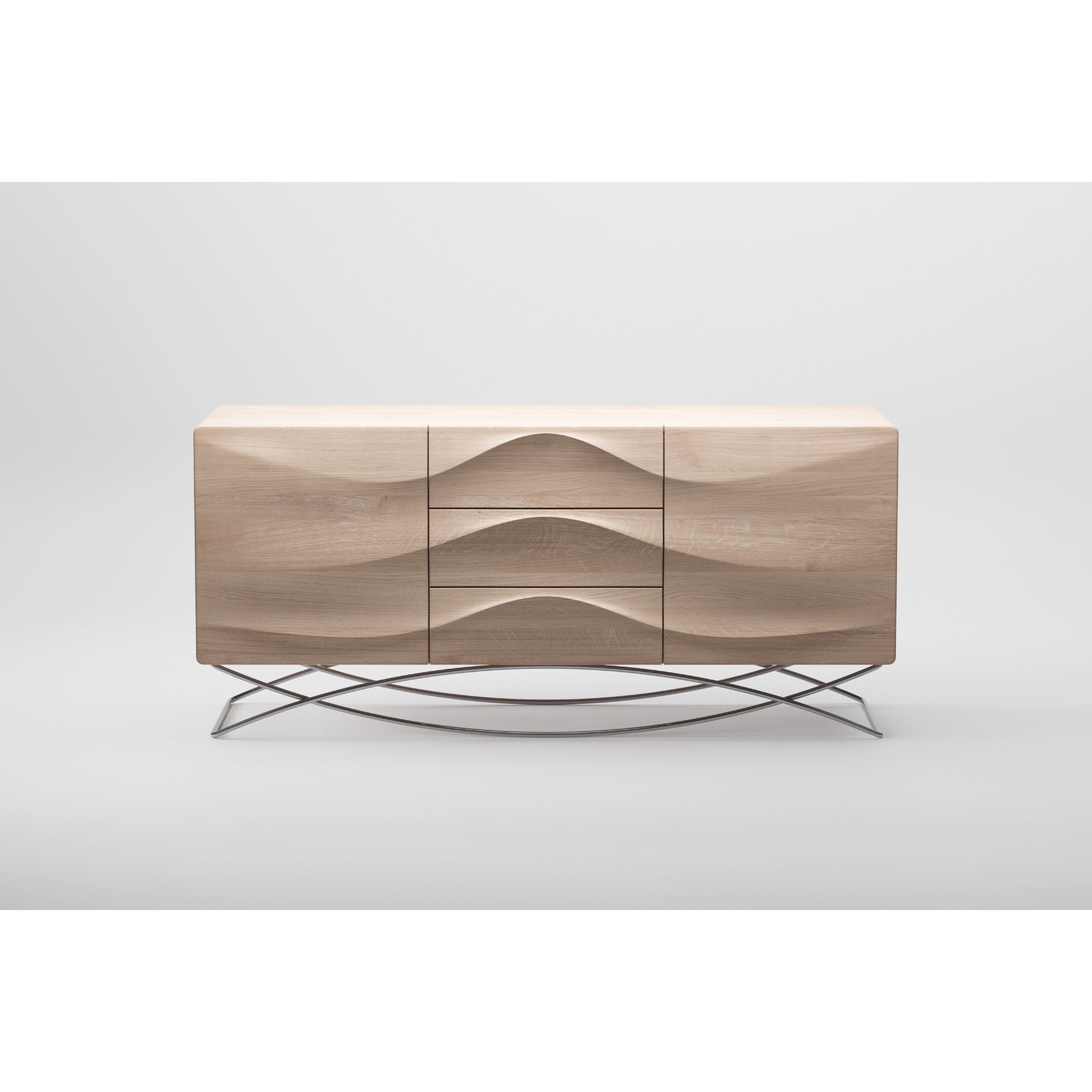 The LASTA Sideboard by Artisan is a sleek, solid wood piece with a minimalist design. It has wavy carved front panels and stands on a criss-cross metal base. Finished with natural oils for eco-friendliness, it presents a striking look against a plain white background.