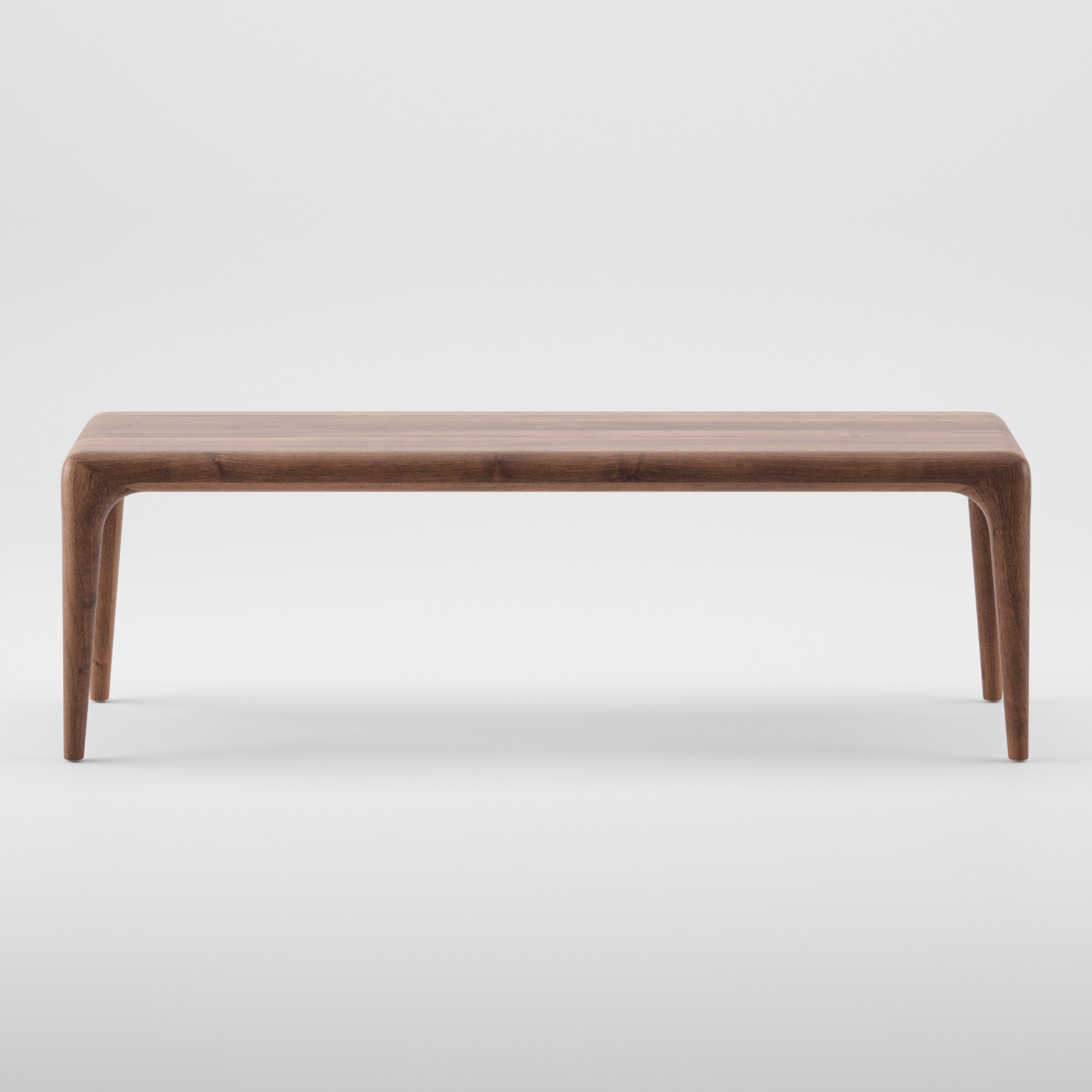 The LATUS Bench by Artisan is a minimalist wooden bench crafted from solid wood, featuring a smooth surface and tapered legs. Set against a plain white background, its elegant design showcases the natural wood grain, finished with eco-friendly natural oils.